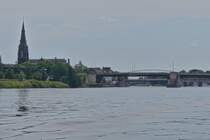 Blick auf die Sint-Martinuskerk in Maastricht, aufgenommen vom Rundfahrtschiff auf der Maas zu Tal, mit dem Durchfahrt unter der Wilhelminabrcke Kanal fr groe Schiffe. 07.2024