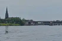 Blick auf die Sint-Martinuskerk in Maastricht, aufgenommen vom Rundfahrtschiff auf der Maas zu Tal, mit dem Durchfahrt unter der Wilhelminabr�cke Kanal f�r gro�e Schiffe. 07.2024