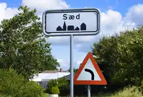 Das Ortsschild an der Einfahrt nach S�d (deutsch Seth) s�dlich von T�nder (deutsch Tondern) in S�nderjylland/Nordschleswig. Aufnahme: 11. August 2024.