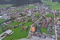 Blick aus einer Gondel der Penkelbahn auf Mayrhofen, mit in der Mitte des Bildes die Talstation dieser Seilbahn. 08.2024