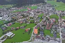 Blick aus einer Gondel der Penkelbahn auf Mayrhofen, mit in der Mitte des Bildes die Talstation dieser Seilbahn. 08.2024