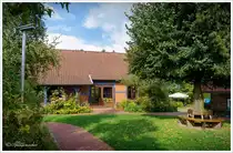Parzival-Hof. Stiftung Leben und Arbeiten. Einrichtung für betreutes Wohnen. Sehr gepflegter Hof, bestehend aus zahlreichen Gebäuden und zum Teil parkähnlichen Anlagen. Auf dem Gelände finden wir auch die Erdgalerie Holländer Windmühle von Quelkhorn. Landkreis Verden. Anfang September 2024