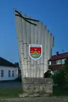 Im Bild das 1996 entstandene Wappen der Gemeinde Peenem�nde mit den drei Kronen zur Erinnerung an die Landung der schwedischen Flotte und den Beginn der schwedischen Herrschaft in Vorpommern. Der gebrochene Faden steht als Symbol f�r die Peenem�ndung in die Ostsee und der Fisch f�r die Fischwirtschaft. (Peenem�nde, September 2024)