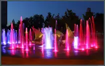 Nachts wird der Springbrunnen an der Skulptur  Trys pauk�čiai  (Drei V�gel) im Stadtzentrum von �iauliai bunt beleuchtet. (28.08.2024)