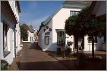 Der Ortskern von Greetsiel ist durch schmale Gassen gekennzeichnet. Hier ist der Fahrzeugverkehr weitestgehend verbannt. Scan eines Dias aus dem Sommer 2004.