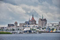 Panorama des Rostocker Stadthafens, mit Nikolaikirche, Marienkirche und Hochhusern entlang der Langen Strae. Im Vordergrund ist der Fluss Warnow. Aufnahme: 8. Juni 2025.