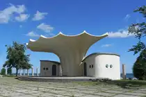 Die Kurmuschel von Sassnitz auf der Ostseeinsel R�gen am 03.07.25.
Der Entwurf von Dietmar Kuntzsch wurde 1988 von Ulrich M�ther fertiggestellt. Ulrich M�ther (* 21. Juli 1934 in Binz) war ein deutscher Bauingenieur, der zu einem bedeutenden Repr�sentanten der architektonischen Moderne z�hlt.