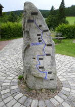 Furtwangen im Schwarzwald, der Stein mit dem Fluverlauf steht an der Donauquelle, genauer an der Quelle der Brig, dem lngsten Quellflu der Donau, Juli 2025