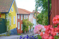 Bunte Holzhuser in Skolgatan in Vstervik (Smland, Schweden). Aufnahme: 20. August 2025.