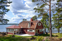 Holzhaus, gestrichen in Falunrot. Das Haus liegt an der Sdspitze von Grns bei Vstervik in Smland, Schweden. Aufnahme: 20. August 2025.