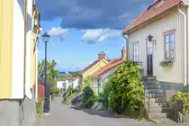 Besv�rsgatan in Oskarshamn. Der Bereich direkt am Hafen, das sogenannte Fnyket, ist aus kleinen Holzh�usern erbaut. Dieses Gebiet ist heute Kulturdenkmal und die schmalen Gassen im Fnyket enden oft an Treppen. Aufnahme: 23. August 2025.