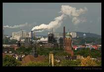 Blick ber Duisburg Hochfeld und Homberg Richtung Moers. Leider kann ich nicht viele Gebude zuordnen, aber mittig rechts ist der Turm der Pauluskirche Hochfeld zu sehen. Ein Teil der Industrieanlagen links davon gehren wahrscheinlich zur ehemaligen Duisburger Kupferhtte (heute DK-Recycling), links daneben sind Gebude von Maersk zu sehen (Auenhafen), dahinter die Verstrebungen der A40-Autobahnbrcke Homberg. Im Hintergrund der Funkturm Moers und rechts die Rheinpreussen-Halde mit dem Geleucht.