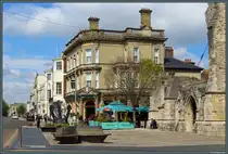 Die High Street f�hrt durch die Altstadt von Southampton und beherbergt zahlreiche Gesch�fte und Restaurants. Rechts ist die Ruine der Holyrood Church zu sehen, vor der auf einem kleinen Platz der Anker der Queen Elisabeth 2 aufgestellt wurde. Im Hintergrund links markiert das Stadttor  Bargate  die historische Grenze der Altstadt. (Southampton, 28.04.2026)