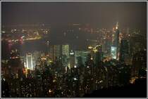 Abendlicher Blick vom Victoria Peak auf Hong Kong. Im Vordergrund sind die Hochhuser des Central Districts von Hong Kong Island zu sehen. Hinter dem Victoria Harbour sieht man in der linken Bildhlfte die Lichter von Kowloon. Scan eines Dias aus dem Januar 1997. 