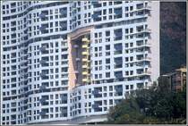 Hier ein Beispiel fr den Einfluss von fung shui auf die Architektur. Um einem Drachen, der hinter dem hohen langgestreckten Gebude am Berghang wohnt, den Blick auf Strand und Meer nicht zu versperren, musste ein groes Loch ins Gebude eingebaut werden. Scan eines Dias aus dem Januar 1997.