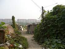 Wohnen in Peking. Im Vordergrund ein (bewohntes) Abbruchviertel, im Hintergrund moderne H�user. 2007