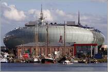 Hinter der Sdkaje des Neuen Hafens und einem alten Hafengebude macht sich das im Sommer 2009 erffnete Klimahaus in Bremerhaven breit. 24.08.2010