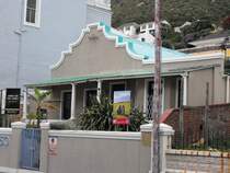 Eingeklemmt zwischen moderneren Kastenbauten stehen noch vereinzelt Haeuser aus der Voortrekker-Zeit. Muizenberg, 20.11.2010
