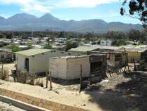 Am Rande der Siedlung entstehen mehr und mehr primitive Behausungen (Shaks).Im HIntergrund die Hottentots Berge. Sir Lovry's Pass Village, 06.12.2010
