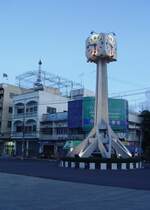 Die  Normaluhr  beim Bahnhof in Buri Ram. Am 10.10.2006 ist um kurz vor 18.00 die Dmmerung bereits hereingebrochen. Weitere 10 Minuten spter ist es bereits stockdunkel