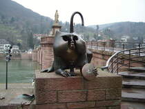 Am ehemaligen nrdlichen Brckenturm war ab dem frhen 17. Jahrhundert das Relief eines Affen angebracht, der sich ans Hinterteil fasste und sich gleichzeitig einen Spiegel vorhielt. Dieses Motiv geht ikonografisch vermutlich auf einen lteren Stadtaffen zurck, der sich an anderer Stelle der Stadt befunden hatte.Bei der Zerstrung von 1689 wurde der Affenturm gesprengt und der Brckenaffe ging verloren. 1977 schrieb der Verein Alt-Heidelberg einen Wettbewerb fr eine moderne Neugestaltung des Brckenaffen aus, der zugunsten eines Entwurfs des Bildhauers Gernot Rumpf entschieden wurde. Die 1979 geschaffene Bronzeskulptur am Sdufer greift das Motiv der Selbstreflexion auf, indem sie dem Betrachter einen metaphorisch zu deutenden Spiegel vorhlt. Neben dem Affen ist das besagte Spottgedicht angebracht. Zwei kleine Mausfiguren erinnern an das kurfrstliche Kornhaus, das sich ehemals an dieser Stelle neben dem Brckentor befand. Der Kopf des Affen ist hohl gestaltet, so dass man den eigenen Kopf in ihn hineinstecken kann – ein Motiv das gerne von Heidelberg-Touristen als Motiv fr Erinnerungsfotos genutzt wird. Am 24.02.11 in Heidelberg Alte Brcke