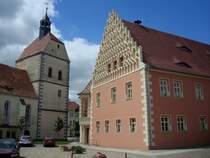 Mhlberg an der Elbe, das Rathaus mit reich ornamentiertem Stufengiebel, links der wuchtige Turm der Frauenkirche, Juni 2010