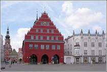 Rathaus und Ratsapotheke (rechts) an der Westseite des Marktplatzes in Greifswald. Links ragt der Turm des Doms St. Nicolai ber die Brgerhuser. Aufnahmedatum: 28.08.2005