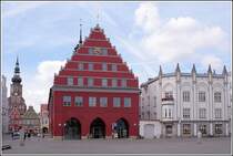 Rathaus und Ratsapotheke (rechts) an der Westseite des Marktplatzes in Greifswald. Links ragt der Turm des Doms St. Nicolai �ber die B�rgerh�user. Aufnahmedatum: 28.08.2005