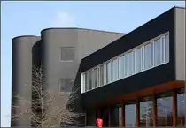 . B�ro- und Ausstellungsgeb�ude Feco Forum, Karlsruhe-Hagsfeld: Die Fassade ist mit schwarzem Wellblech verkleidet. Dazu im Kontrast die wei� gerahmten Fenster der B�ros und die h�lzerne Schaufenserfl�che. 01.03.2011 (Matthias)