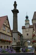 Rothenburg ob der Tauber - Brunnen an der Rdergasse (Juli 2011), dahinter der Rderbogen.