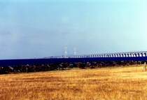 Hierbei handelt es sich um die Storebeltbrcke zwischen der Insel Fnen und der Insel Seeland. Der Auftrag zum Bau der Brcke ber den Groen Belt(Storebelt) wurde am 12. Juni 1986 vom dnischen Parlament erteilt. Am 14 Juni 1998 wurde das Bauwerk fr den Verkehr freigegeben. Von der Insel Fnen aus, bei der Stadt Nyborg, fhrt zuerst eine knapp 7 Km lange Auto-und Eisenbahnbrcke auf die kleine Insel Sprog. Die Strae besitzt jeweils 2 Fahrspuren in jede Richtung und die Bahntrasse verluft zweigleisig. Von der Insel Sprog aus berquert die Autobahn mit einer weiteren knapp 7 Km langen Brcke die Ostsee bis zur Insel Seeland, nahe der Stadt Korsr, whrend die Bahntrasse ab der Insel Sprog in einem 8 Km langen Bahntunnel bis zur Insel Seeland verschwindet. Die beiden Pylonen des Brckenteils von Sprog nach Seeland bilden mit knapp 250m den hchsten Punkt Dnemarks. Bei sehr extremen Wetterbedingungen kann es passieren das die Brcke fr den Verkehr zeitweise gesperrt werden muss. Das Bild enstand bei Nyborg auf Fnen (gescanntes Bild)