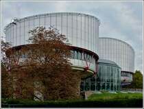 - Straburg, die Stadt der architektonischen Gegenstze - Das Gebude des Europischen Gerichtshofs fr Menschenrechte wurde vom britischen Architekten Richard Rogers entworfen und nach dreijhriger Bauzeit im Jahr 1995 fertiggestellt. Aus der Luft betrachtet, hat das Gebude die Form einer Waage, wobei die runden Sitzungssle die Waagschalen darstellen. Diese Struktur setzt sich auch in der Stahlkonstruktion im Gebude fort. Hier „schweben“ die Sitzungssle wie zwei Waagschalen gleichsam ber dem Boden. Gleichzeitig erinnert das Bauwerk durch seine Lage am Fluss und die hohen Aufbauten zwischen den beiden Slen auch an ein Schiff. 30.10.2011 (Jeanny)
