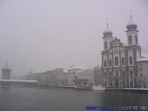 Die verschneite Jesuiten Kirche rechts, Links der der Wasserturm hinter der Kapellbrcke