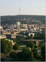 Stuttgart vom Hauptbahnhofturm aus gesehen. Die Blickrichtung ist nach S�den zum Hohen Bopser mit dem Fernsehturm. Das Landtagsgeb�ude ist rechts unterhalb der Bildmitte zu erkennen. Bei der Parkanlage im Bild unten handelt es sich um den Oberen Schlo�garten. �ber den Mittleren und Unteren Schlo�garten parallel zu den Bahnanlagen erreicht man den Neckar. Dort schlie�t sich dann der Rosensteinpark und die Wilhelma an. Der Rosensteinpark wurde zur IGA `93 �ber das Leibfriedscher Garten und Wartberg zudem mit dem Killesbergpark verbunden. Bis zum Killesberg betr�gt die L�nge 8 km. Von dort geht die Gr�nzone �ber die Feuerbacher Heide in den Kr�herwald �ber. Man kann also ohne ebenerdig eine Hauptstra�e �berqueren zu m�ssen vom Stuttgarter Schlo�platz bis zum Killesberg im Gr�nen wandern. Die durchschneidenden Verkehrsadern werden meist mittels filligraner Br�cken �berquert. Aufgrund seiner Form wird diese f�r Stuttgart sehr wichtige Gr�nzone als  Gr�nes U  bezeichnet. 22.9.2005 (Matthias)