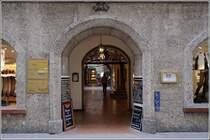 Salzburg. In der Getreidegasse gibt es etliche Durchh�user. Sie erm�glichen jedem die Durchquerung des Privathauses, um zur Parallelstra�e zu gelangen. Hier beispielweise von der Getreidegasse 21 zum Universit�tsplatz 8. Der helle Punkt neben der Person ist der Ausgang auf der anderen Seite. 17.01.2012