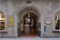 Salzburg. In der Getreidegasse gibt es etliche Durchh�user. Sie erm�glichen jedem die Durchquerung des Privathauses, um zur Parallelstra�e zu gelangen. Hier beispielweise von der Getreidegasse 21 zum Universit�tsplatz 8. Der helle Punkt neben der Person ist der Ausgang auf der anderen Seite. 17.01.2012