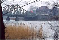 Blick auf die Potsdamer Seite der Glienicker Brcke zwischen West-Berlin und Potsdam Ende der 1970er/Anfang der 1980er Jahre. Die sowjetische Fahne flattert im Wind, das DDR-Enblem hngt in der Brckenmitte. Das Winterwetter passt zu einem Agentenfilm mit Agentenaustausch. Scan vom Dia.