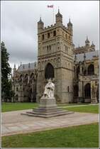 Exeter. Die St. Peter's Cathedrale von Norden mit einem der beiden normannischen Trmen. Der Kirchenbau wurde im 14. Jahrhundert beendet. Davor das Denkmal von Richard Hooker (1554 - 1699), einem anglikanischen Theologen zu sehen. 30.06.2012.