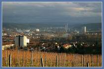 Blick vom Burgholzhof ins Stuttgarter Neckartal im letzten Sonnenlicht vor einer Schlechtwetterphase. Markante Punkte sind das Daimler-Stadion und das Mercedes-Benz-Museum links, das Kraftwerk Gaisburg rechts der Mitte und der Gaskessel in Gaisburg links. Im Hintergrund ist die Schwbische Alb erkennbar. 4.1.2007 (Matthias)
