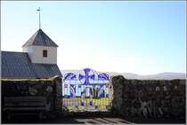 Den Zugang zum Kirchhof der Olavskirche in Kirkjubour ziert eine glserne Pforte. 21.09.2012