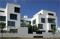 Wohnanlage  Rosenpark  in Stuttgart. Die Gebude wirken einerseits vielfltig und abwechslungsreich durch die Vor- und Rcksprnge der kubischen Bauformen und die versetzt angeordneten groflchigen Fenster. Einheitlichkeit entsteht durch die wenigen Materialien: weier Putz, mit Licht- und Schattenwirkung unterbrochen lediglich durch die dunklen Glasflchen. Fr mein Empfinden eine gestalterisch sehr gelungene Anlage. 30.5.2007 (Matthias)