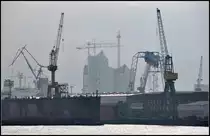 ...im Hintergrund die Elbphilharmonie - Die Baustelle der Hamburger Elbphilharmonie wird durch zwei Hafenkr�ne gerahmt. 11.04.2012 (Jonas)