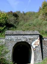 Deutschland, Landkreis Vulkaneifel, Verbandsgemeinde Daun in Rheinland-Pfalz, Maare- Mosel-Radweg von Schalkenmehren nach Daun, Tunnel Groes Schlitzohr, ehemals Schalkenmehrener Tunnel. Der Tunnel (560 m) liegt 2 km vom Bahnhof Daun entfernt unter dem  Ltzelbacher Kopf . Der Tunnel ist heute als Teil des MMR beleuchtet und trgt am Eingang die Aufschrift  Groes Schlitzohr . Dies deutet auf eine Fledermausart hin, die sich im Tunnel angesiedelt hat. 31.08.2002