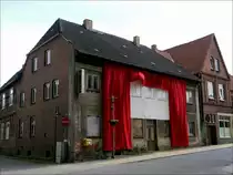Was will uns der K�nstler damit sagen - ein roter Vorhang am verwahrlosten Haus, worin sich ehemals das Kino befand? Wittenburg, Gro�e Stra�e; 24.06.2013
