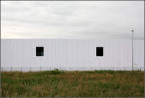 . Groer Rundbau - Die Fassade wird dort wo keine Tore fr die LKWs sind, durch fast quadratische Fensterffungen gegliedert. Vitra, Weil am Rhein, 20.06.2013 (Matthias)