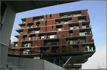 Auskragend: die neuen Wohn- und B�rogeb�uden ragen freitragend �ber den Fu�g�ngerweg am Sandtorhafen. Bei dem im Bild gezeigten Geb�ude handelt es sich um ein Wohnhaus, das eigentlich aus zwei Teilen besteht, die �ber eine mittige Glashalle senkrecht zum Sandtorhafen miteinander verbunden sind. Geplant wurde dieses 2005 fertiggestellte Geb�ude von APB Architekten aus Hamburg.  14.7.2007 (Matthias)