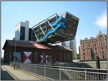 Am sdlichen Ende des zum Medienhafen gehrenden Hafenbeckens  findet man den  Wolkenbgel , der quer ber ein altes, denkmalgeschtztes Hafengebude gebaut wurde. In dem alten Gebude befindet sich eine Diskothek, in dem Baukrper darber u.a. Bros. (15.07.2007)