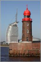 Bremerhaven. Ein alter und ein junger Turm als Nachbarn. Der kleine, 14 m hohe Leuchtturm auf der nrdlichen Geestemole ist 1914 - also vor 100 Jahren - in Betrieb genommen worden. Das bis zur Spitze ber 140 m hohe Atlantic Hotel Sail City wurde 2008 erffnet. 02.02.2014