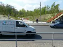 Zerschnittene Stadt: zwischen der Fotoposition und der anderen Stra�enseite f�hrt die Verbindung zwischen Nord- und S�dteil des Gleisdreieck-Parkes entlang. Zudem f�hrt hier der Fernradweg Berlin- Leipzig entlang. Bei der Einweihung des S�dteils wurde schnell deutlich, dass die L�sung - n�mlich ein hunderte Meter weiter Umweg zu einer Fu�g�ngerampel, von den zahlreichen Parkbesuchern oft nicht angenommen wird. Viele kletterten �ber den Zaun und querten die Stra�e so. Schlie�lich erkannte man, dass die ehemaligen Bahnbr�cken ja vielleicht eine gute Alternative w�ren, und machte sie gangbar. Somit besteht nun eine komfortable und sichere Querungsm�glichkeit f�r die Yorckstra�e. 21.4.2014