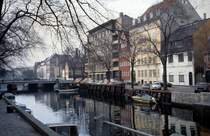 Kbenhavn / Kopenhagen: Frhlingsstimmung am Kanal im Stadtviertel Christianshavn in den 70er Jahren. Die Strasse rechts im Bild heisst Overgaden neden Vandet: 'Overgaden' hiess am Beginn 'Ufergade', vom deutschen Wort 'Ufer' und dem dnischen Wort fr Strasse 'gade' zusammengesetzt. 'Neden Vandet' ist der Beiname dieser Strasse, weil sie in der ursprnglichen Niederstadt oder Unterstadt (neden = dt. unten) des Stadtteils lag.